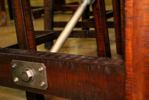 Industrial accents, such as this stainless steel nut and bolt on a dining set, are a current trend showing at Woodshed Furniture.