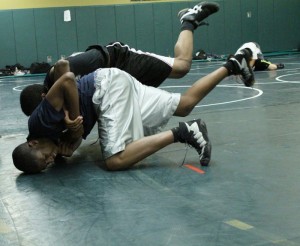 AJ Edwards (front) latches on to the wrist of his opponent Wayne Harris, who wrangles both into a backwards somersault.