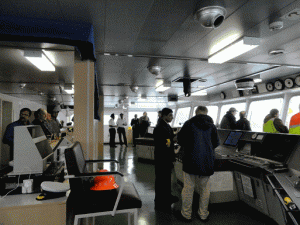 Captain Nelson Ambosa (center left) discusses features of the Macaw Arrow with a visitor.