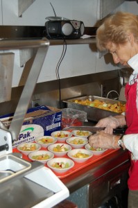 Elizabeth Raybould prepares fresh fruit to be included in a lunch at the Olympia Senior Center.