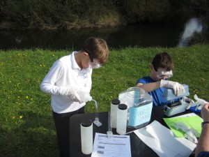 On Water Quality Monitoring Day, Kai Nicholas and Nicholas Heelan test water samples from the Deschutes River.