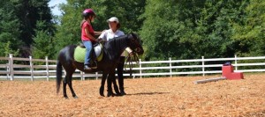 Keev Farm Owner and Trainer, Tracie O’Brien helps a young rider on the farm’s Shetland Pony named “Lil’ Britches”. ©2014 Keev Farm