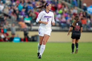 Alyssa controlling goal area as University of Portland defender. 