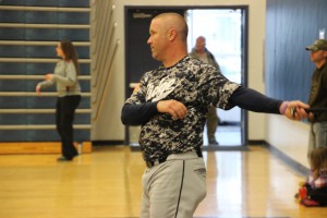 Coach Chad Arko hits his infielders some grounders in the gym.