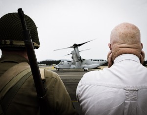 A Vietnam war re-enactor and friend watch a Marine MV22 Osprey depart from the 2015 Olympic Flight Museum Air Show. Photo credit: John Korvell.