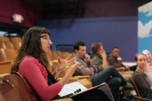 Stage Manager Alexis Sarah gives feedback to a speaker while other TEDxOlympia team members listen.