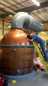 Bourdon, seen here inspecting the historic still-condenser, will modify it for use at Sandstone Distillery.