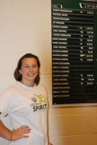 Hannah Barker stands next to a display showing the 6 school records she set during her freshman year.