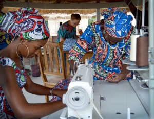 Women in Togo sewing items for the new Queen Alaffia accessory line with founder Rose Hyde in the background.