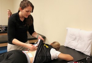 There's more to athletic training than just taping. Rebekah McFann uses an E-stem machine on an athlete's back, to provide pain relief from aching muscles.