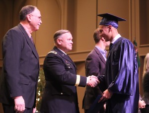 Alec Frazier of Rochester shakes the hand of Major General Bret D. Daugherty of the Washington National Guard during commencement proceedings on December 19.