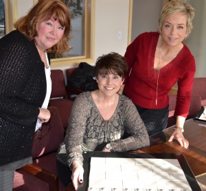 Kim Showalter(l) and Helena Rice (r) review design choices with Deanna Collins (c) for new luxury homes on Select Homes Sites.
