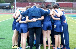 Mike Michaels takes one more moment to say an encouraging prayer with his athletes before they run.