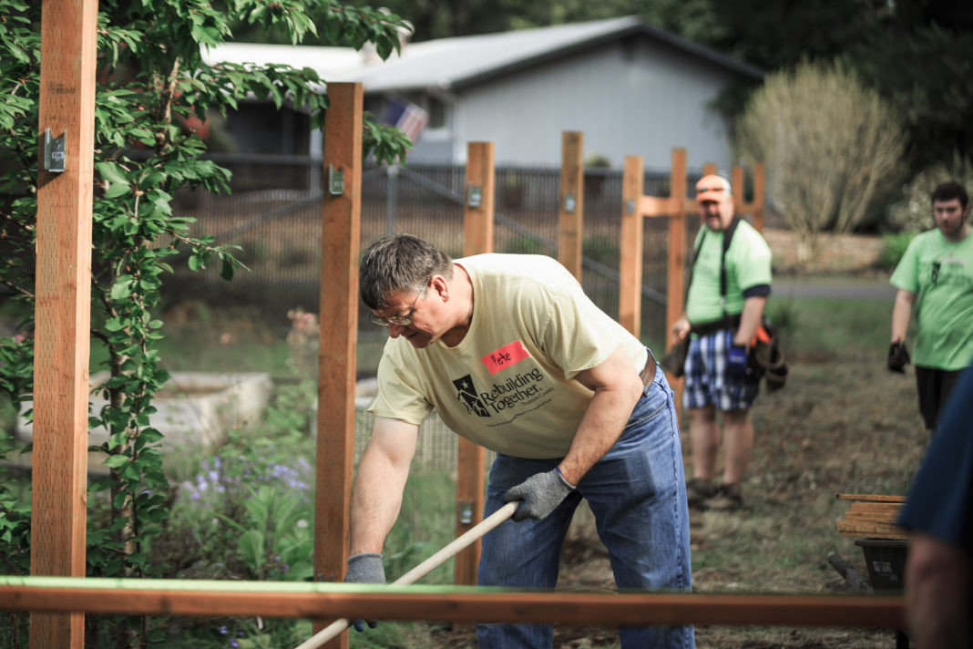 Rebuilding Together Thurston County Pete Kmet raking long wide shot