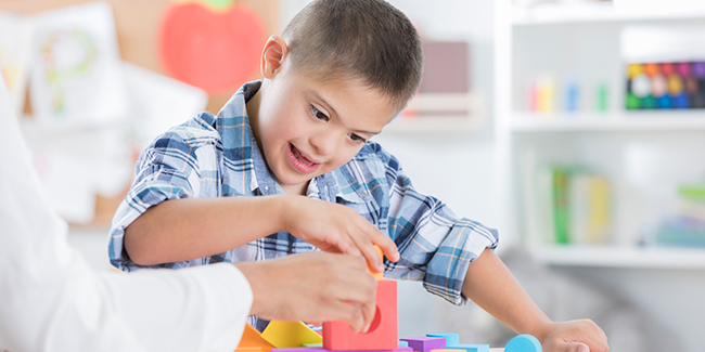 Special needs boy plays with building blocks