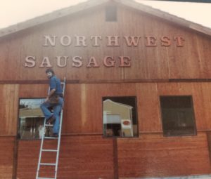 Northwest Sausage & Deli Dick putting up sign