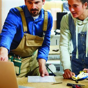 Workers Discussing Over Laptop In Sofa Workshop