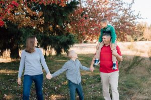 family of four, with one child on dad's shoulders