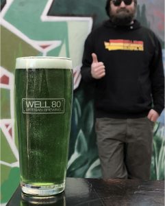 glass of Irish Cream Dark Czech Lager with man standing behind it