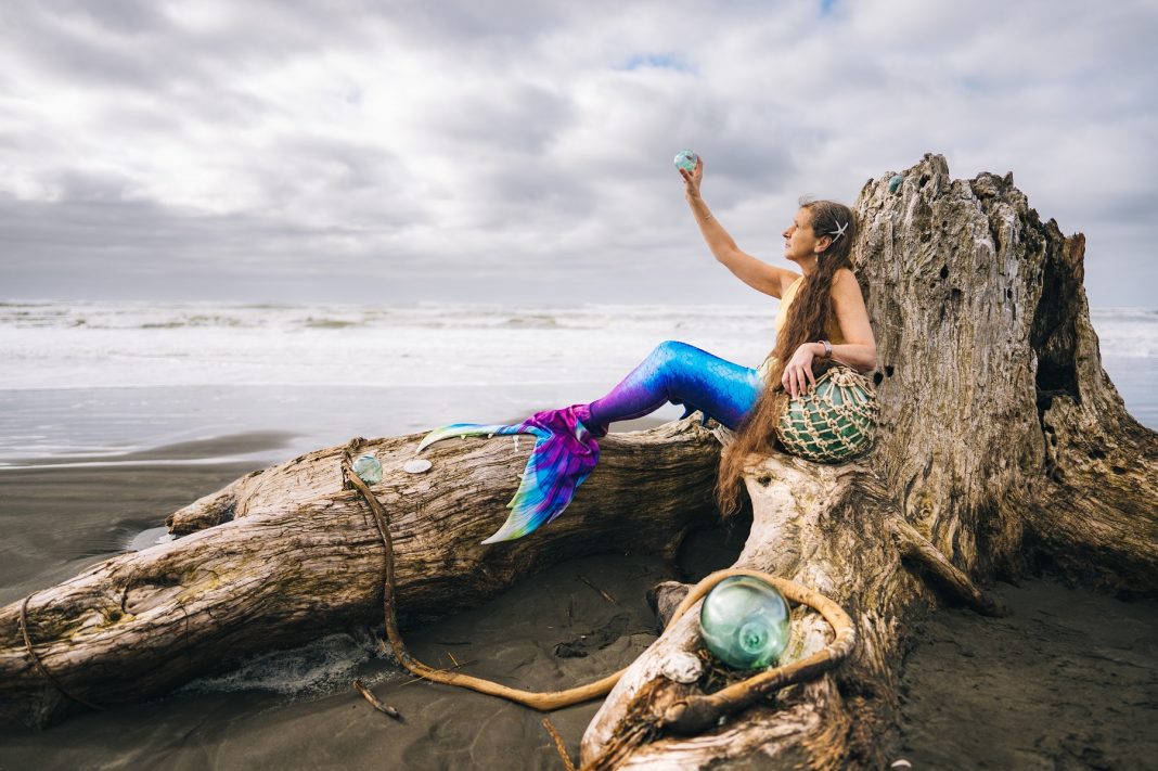 mermaid sitting on drift wood in Grays Harbor