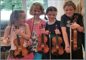 four kids holding violins in a row