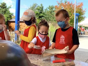 kids in masks at the Hands On Children's Museum playing with sand