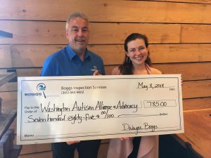 Dwayne Boggs and a lady holding a  large donation check to Washington Autism Alliance