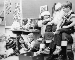 black and white photo of santa and elves visiting children