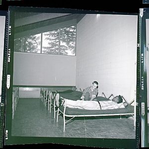 black and white photo of sparse beds in a bare room at  Cedar Creek Youth Camp 