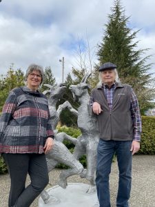 Larry and Cherie Challain standing next to their dancing goat statue