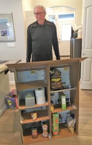 Jim Gebhardt standing behind a cardboard prototype of Tumwater's first Little Free Pantry