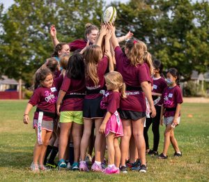 Large group of girls in a huddle during rugby in Thurston County