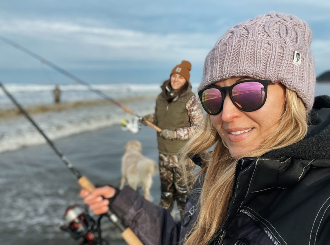 two women surf fishing in on the beach