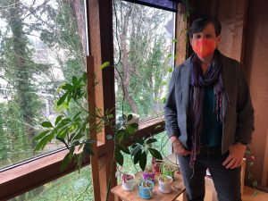 Registered dietician nutritionist Laura Woodworth standing by windows with a plant next to her