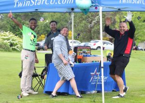 Four people in a Twinstar Credit Union pop up tent on a golf course
