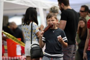 A kid easting a corn dog at the Lacey South Sound BBQ Festival
