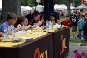 People at a table eating chicken wings for an eating contest at the Lacey South Sound BBQ Festival