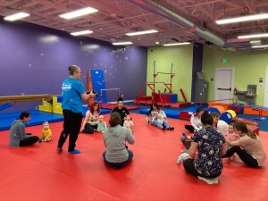Mom and their tots gather with Mr. Tim for bubble time as class comes to a close at The Little Gym Olympia. 