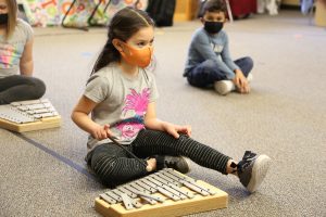 Young girl sitting with a xylophone 