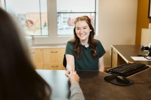 student teller helping a customer in OlyFed's BankWork$ program