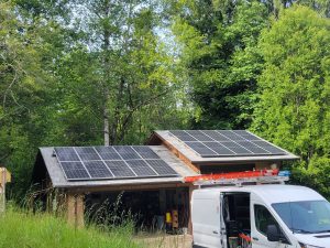 Garage with a van out front and solar panels on roof