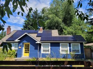 blue house with solar panels on roof in Olympia installed by Olympia Community Solar