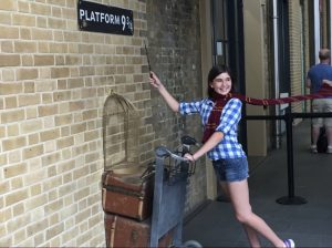 Adolescent la Platforma 9 3/4 cu o baghetă și eșarfă Harry Potter