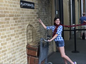 Teen at Platform 9 3/4 with a wand and Harry Potter scarf