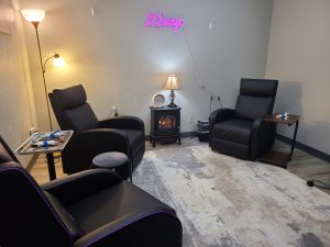 waiting room atRejuvenate IV Hydration & Wellness Center with three leather chairs, table and lamp