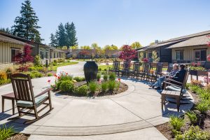 Fieldstone Memory Care courtyard with round stone walkway, benches and shrubs