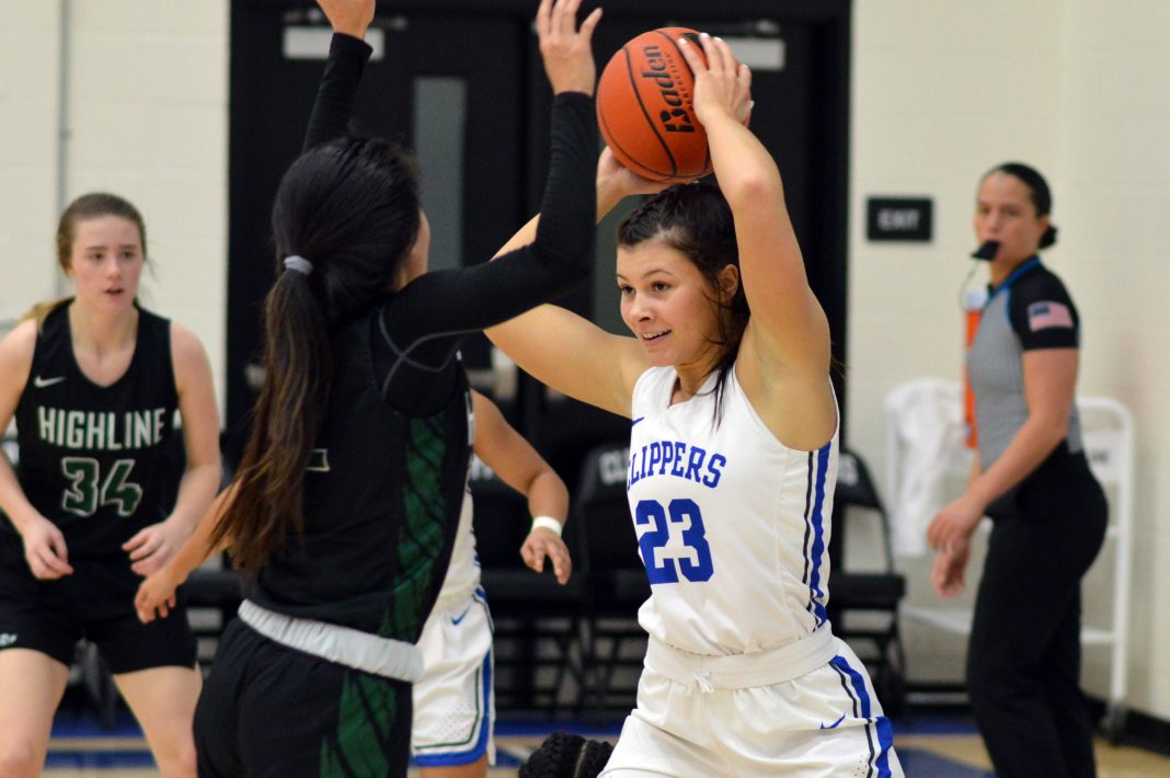 SPSCC basketball player Payten Foster holds the ball over her head on the court