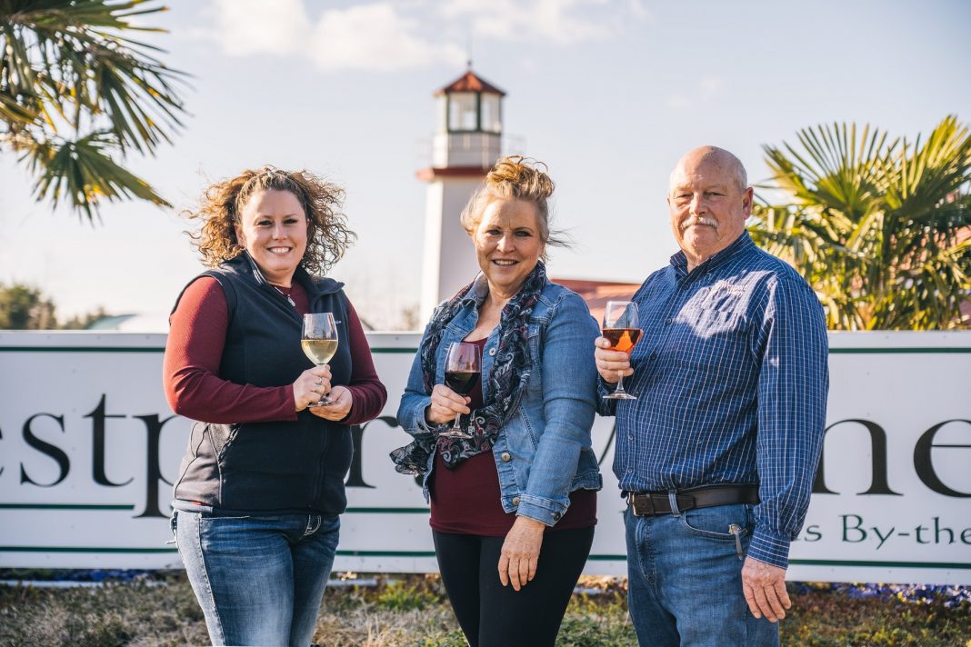 three people with wine glasses standing outside Westport Winery