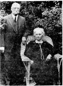 black and white photo of Jesee and Ida Hit, Ida is sitting down and Jesse is standing next to her