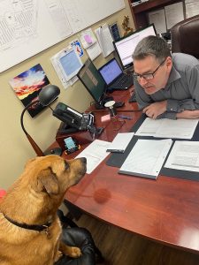 Capital Mall General Manager Kevin Johnstone and dog sitting at a desk